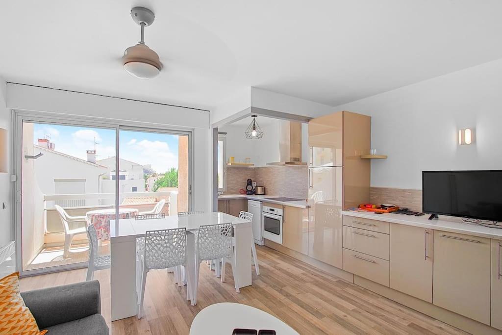 a kitchen with a table and a dining room at Appartement Calme et Moderne avec vue mer 74 in Canet-en-Roussillon