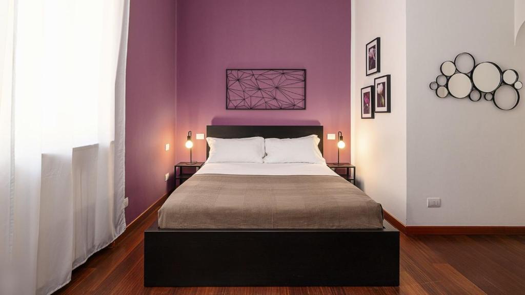 a bedroom with a large bed with purple walls at "Violet Dream" - DUOMO CityLife in Milan