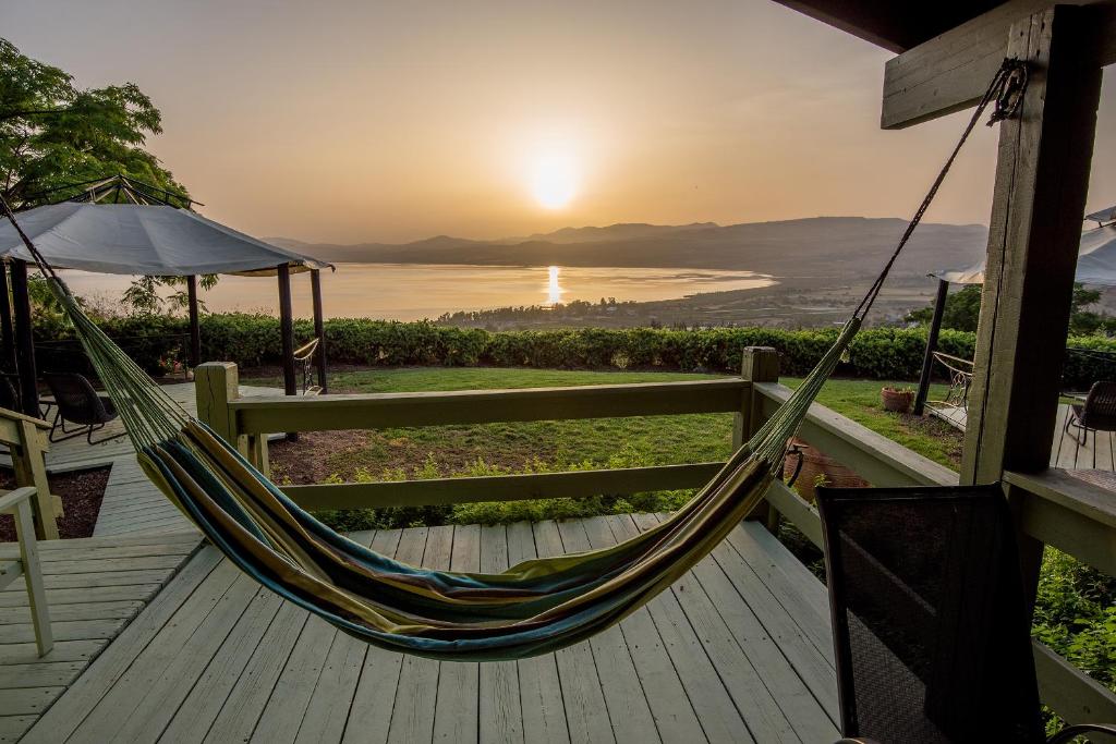 a hammock on a deck with a view of the ocean at Sea of Galilee Panoramic View in Moshav Ramot