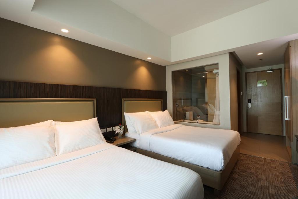 Postel nebo postele na pokoji v ubytování Sotogrande Hotel Katipunan