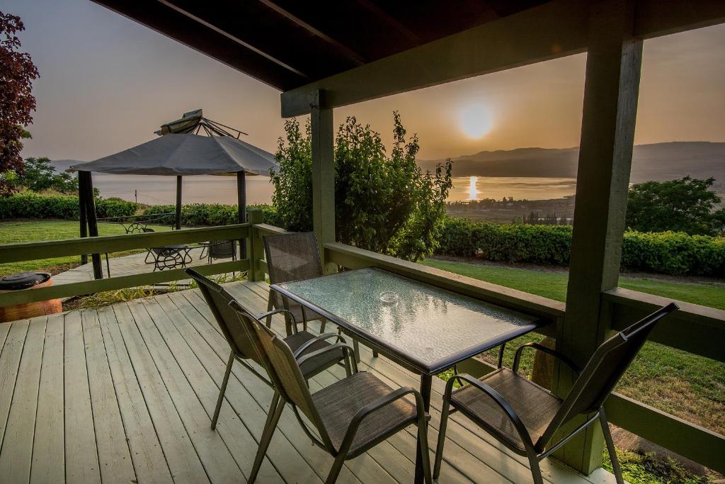 a table and chairs on a deck with a view of the ocean at Sea of Galilee Panoramic View in Moshav Ramot