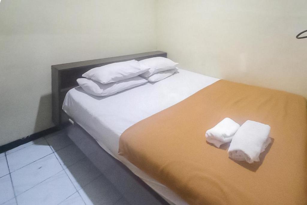 a bedroom with a bed with two towels on it at Hotel Malang near Alun Alun Malang RedPartner in Malang