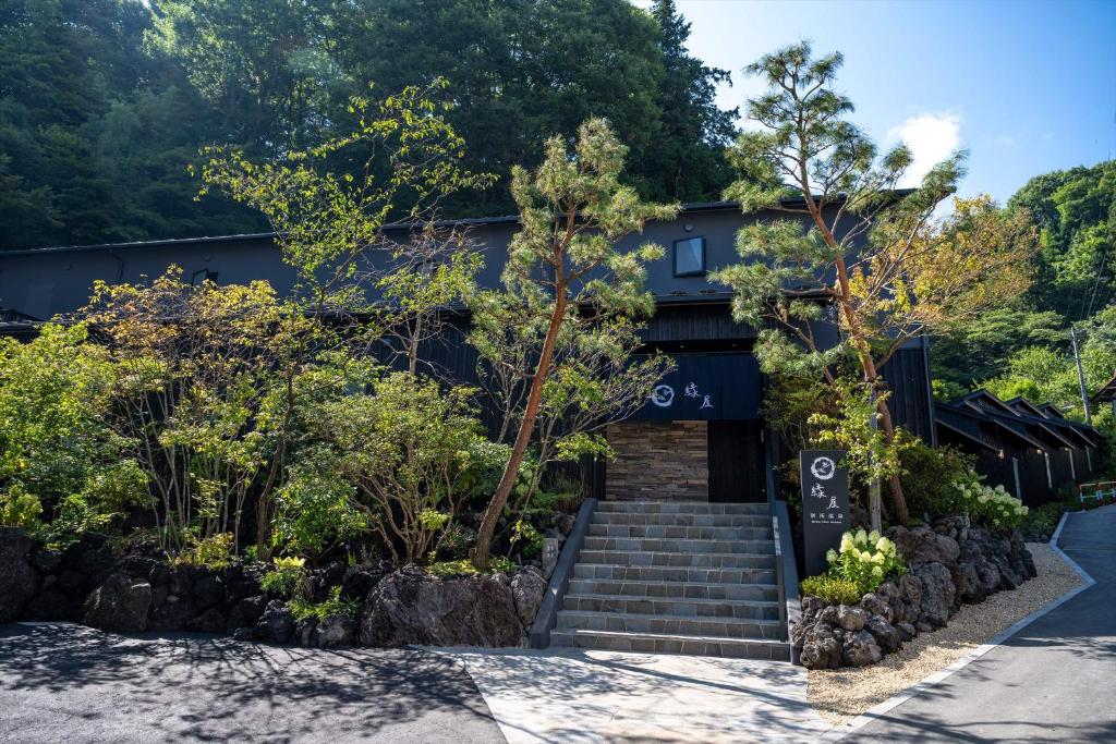 上田的住宿－Bessho Onsen Midoriya，前面有楼梯和树木的建筑