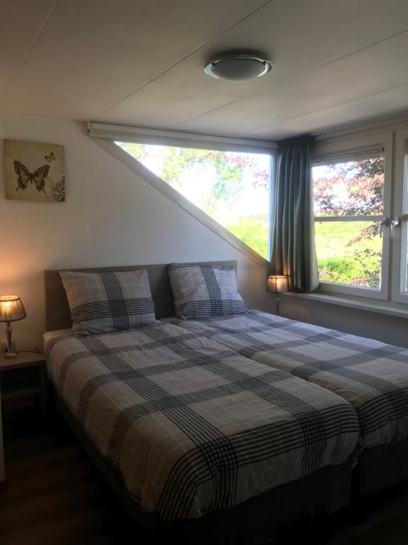 1 dormitorio con 1 cama y ventana grande en Appartement, en Opheusden