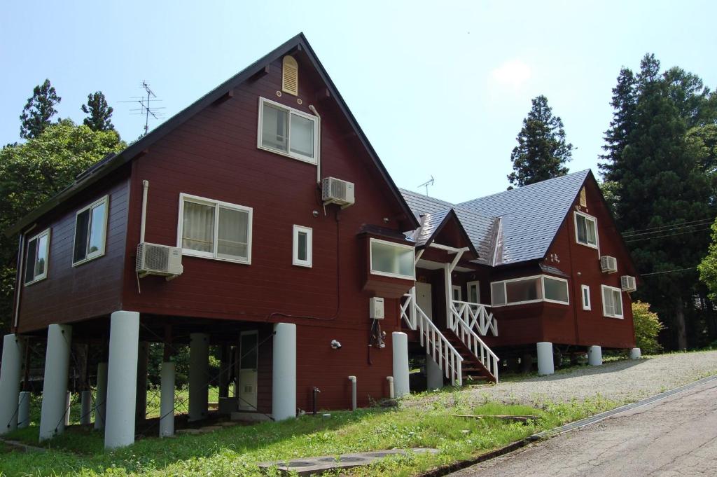 a large red barn with white columns at Shakunagedaira Rental cottage - Vacation STAY 18464v in Numanokura