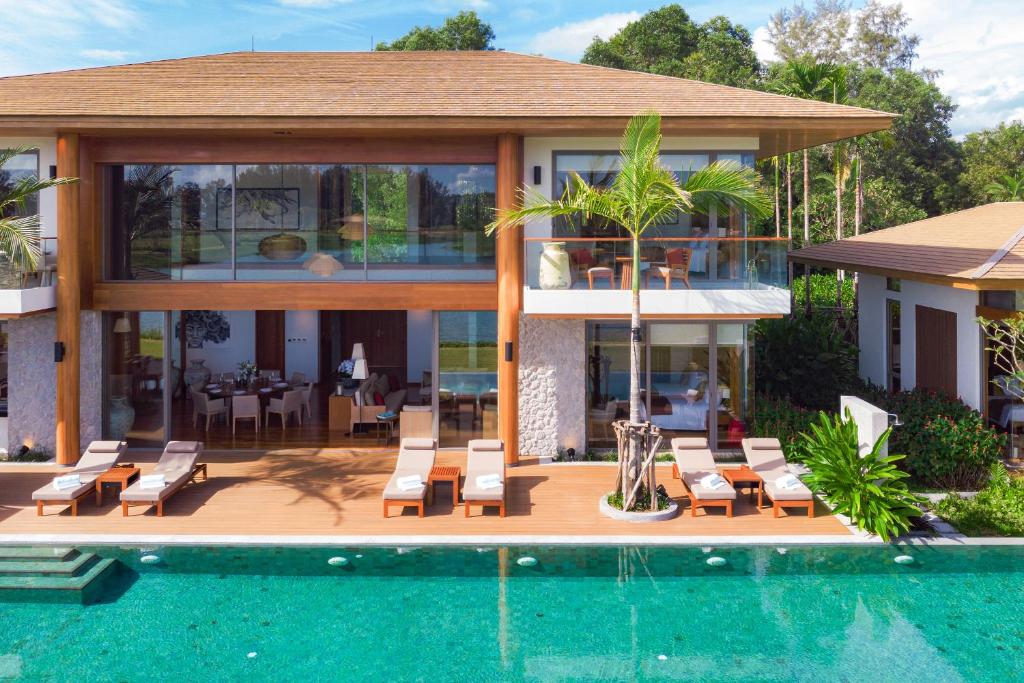 a house with a swimming pool next to a house at Aquella Lakeside Villas in Thai Muang