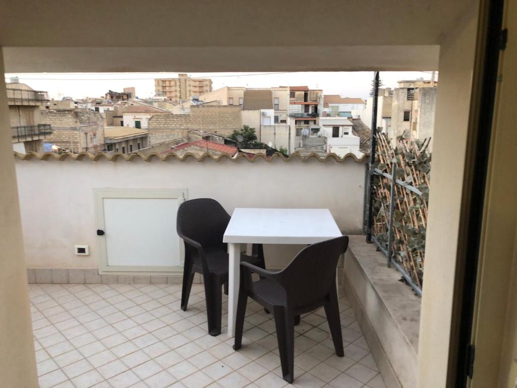 una mesa y sillas en un balcón con vistas en Mansarda Mentana due en Vittoria