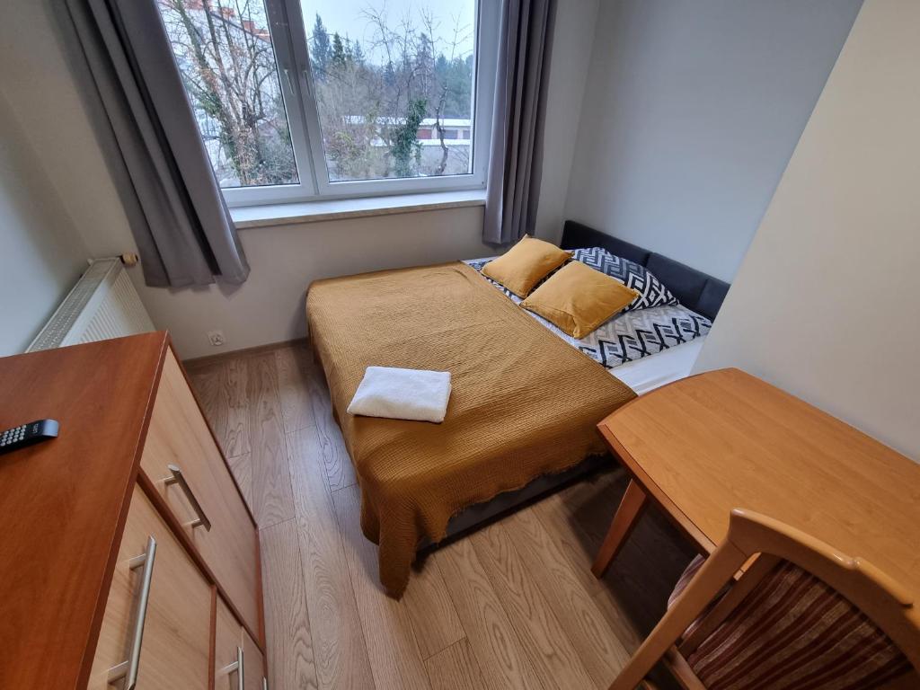 - une petite chambre avec un lit et une fenêtre dans l'établissement Apartament Olszewskiego, à Wrocław