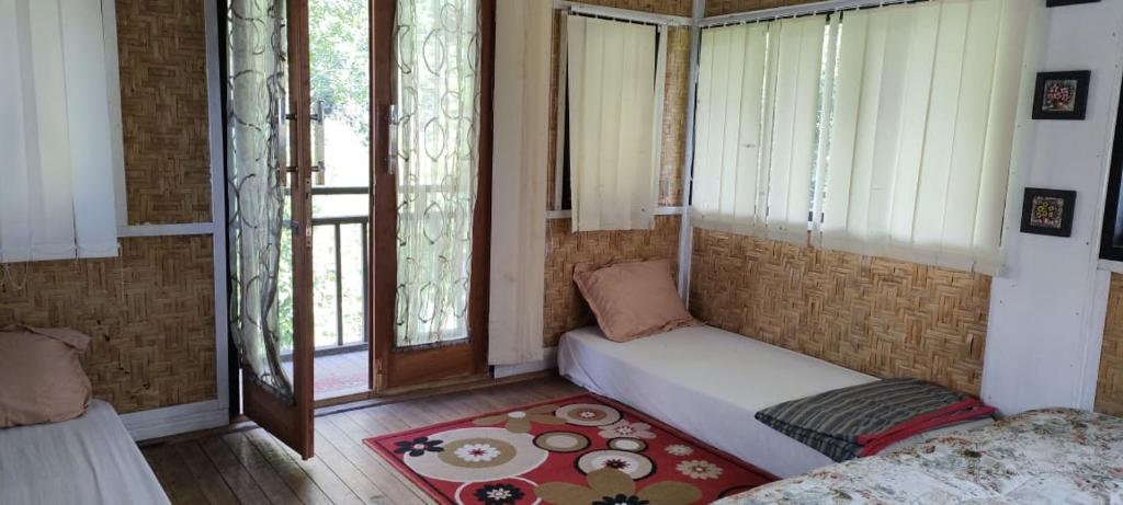 Habitación pequeña con cama y ventana en Roemah Abdoe, en Arau