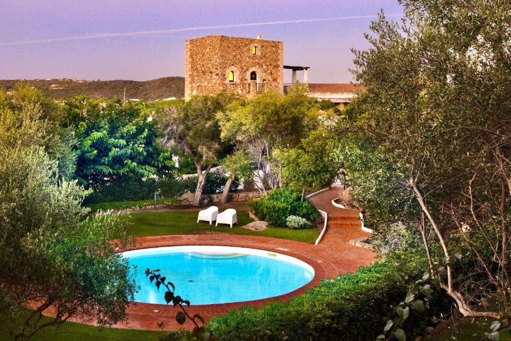 uma villa com uma piscina num jardim em ISA-Residence wityh swimming-pool near Porto Cervo and only 350 meters from the beach em Liscia di Vacca