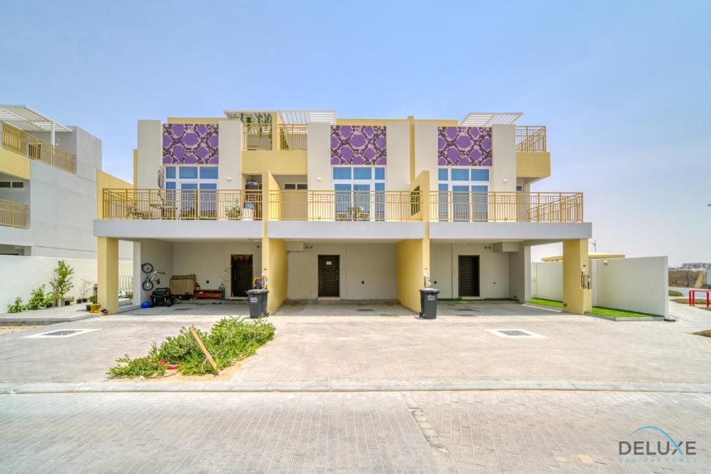 an empty parking lot in front of a building at Magnificent 3BR Townhouse at DAMAC Hills 2, Dubailand by Deluxe Holiday Homes in Dubai