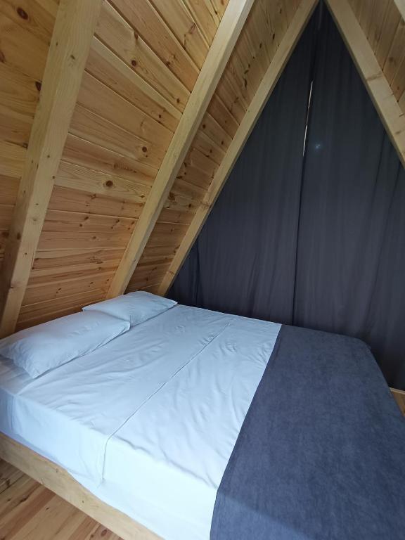 a bed in a room with a wooden ceiling at Mira bungalov rize in Ardeşen