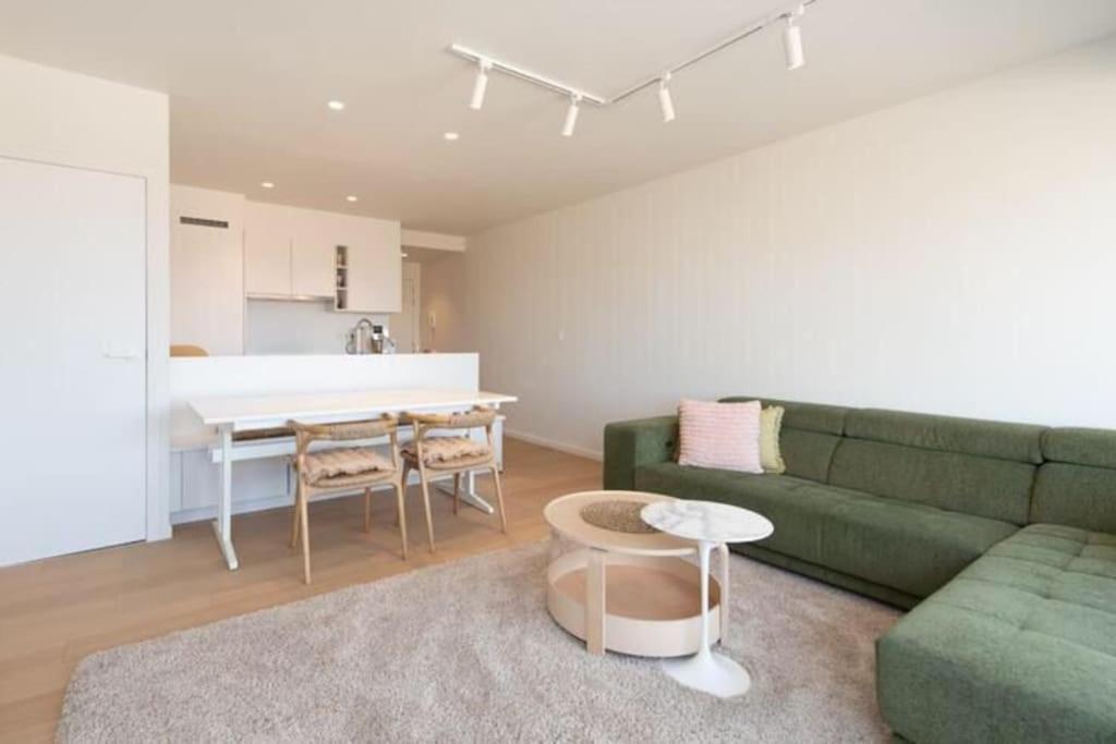 un salon avec un canapé vert et une table dans l'établissement Panne-O-Rama, à La Panne