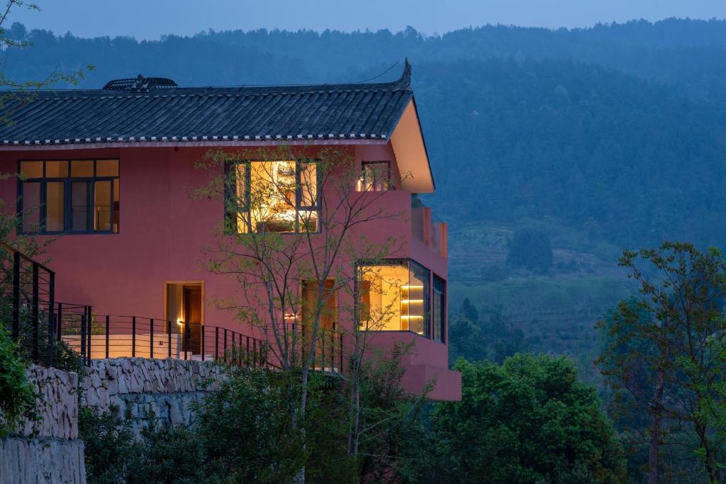 a house on a hill with its lights on at Erzhuo Valley in Furong Town - Among the Clouds 