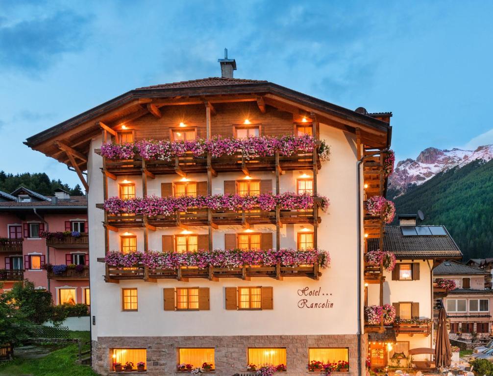 a building with flowers on the side of it at Romantic Charming Hotel Rancolin in Moena