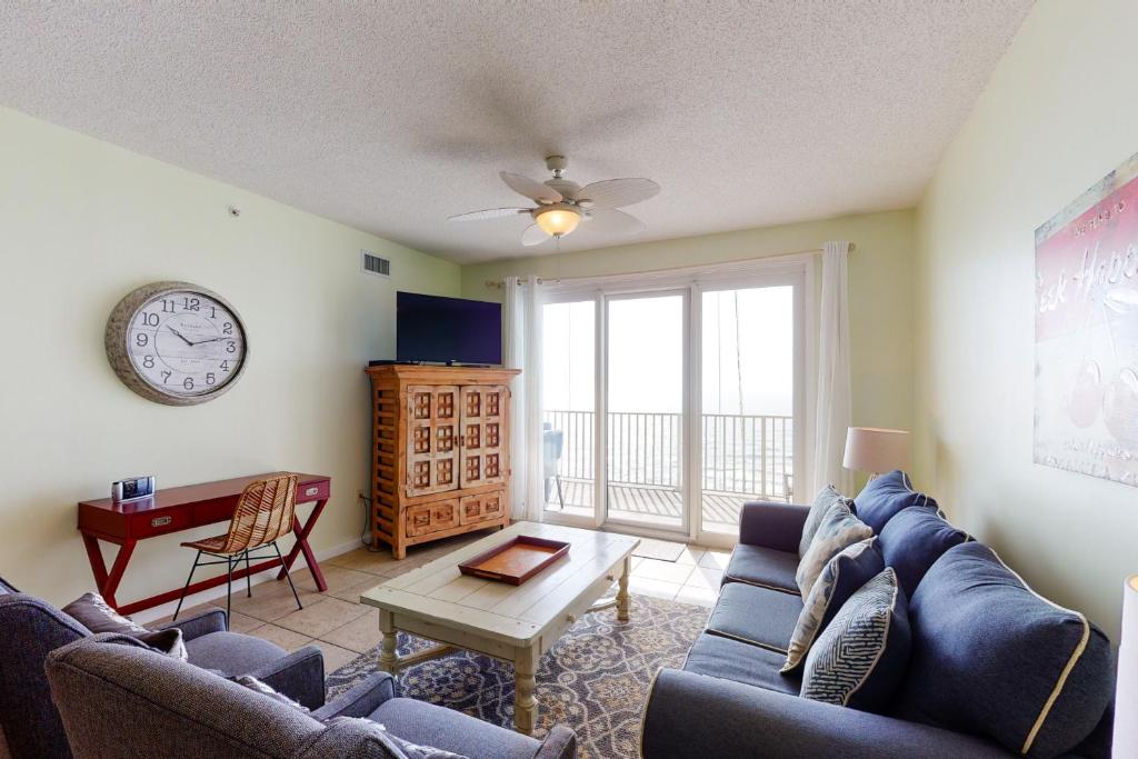 a living room with a couch and a table and a clock at Windemere 0805 in Perdido Key