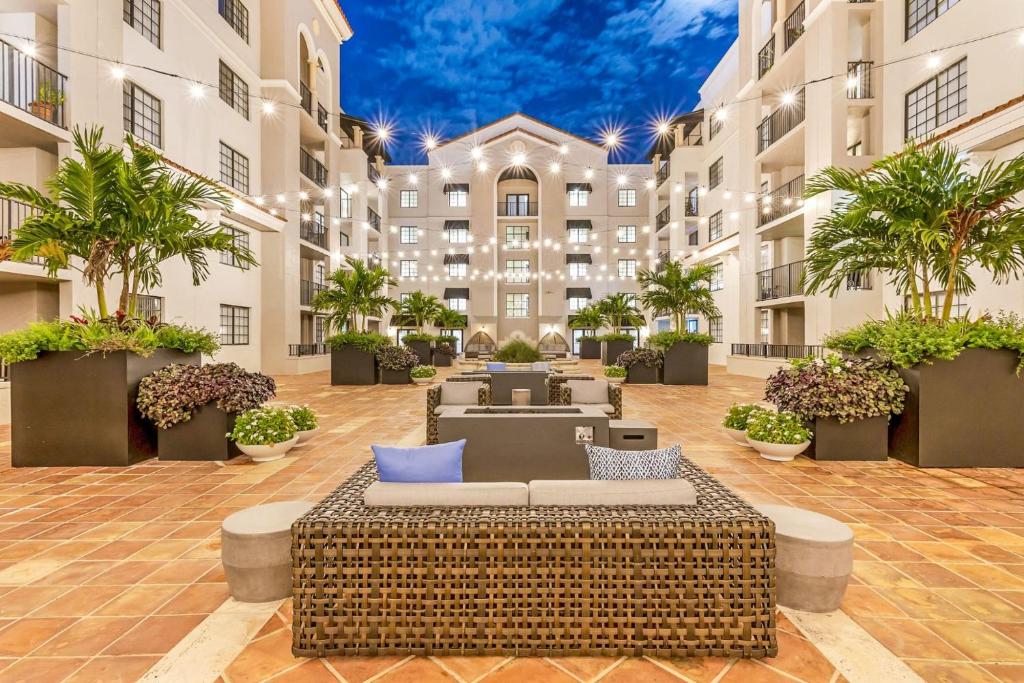 a hotel courtyard with a couch in front of a building at Stylish Modern Apartments at Gables Grand Plaza in Miami in Miami