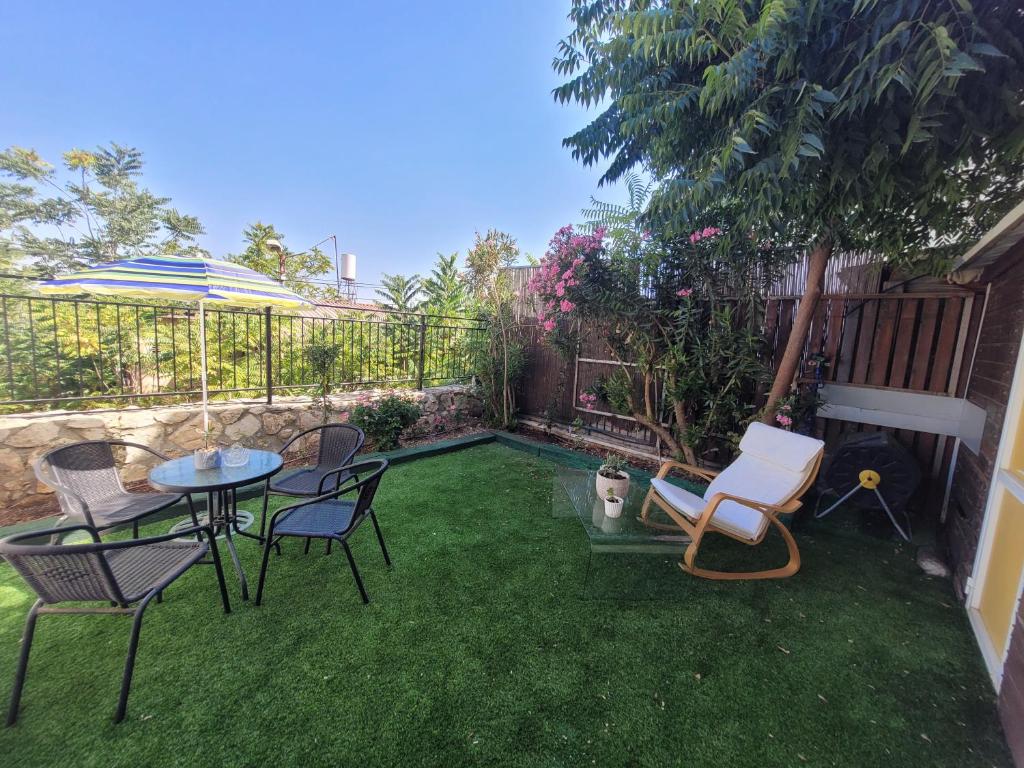 a backyard with chairs and a table and a fence at הבית באשכולות in Ma'alot Tarshiha