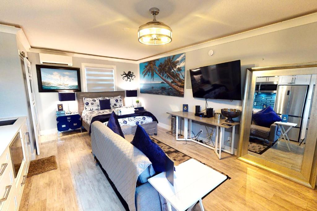 ein Wohnzimmer mit einem Sofa, einem Bett und einem TV in der Unterkunft Ocean Jewel Condos Unit 244 in Daytona Beach