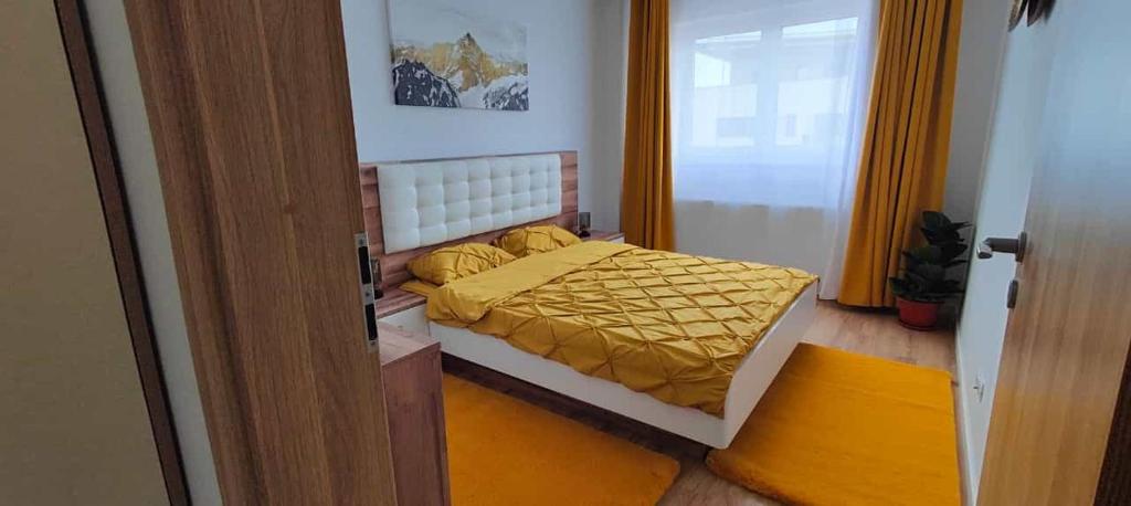 una camera con letto e copriletto giallo di Rooftop condo 45 a Braşov