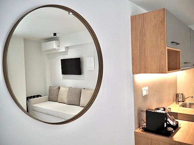 a mirror reflecting a room with a couch and a kitchen at La Mer Luxury Apartments in Ierissos