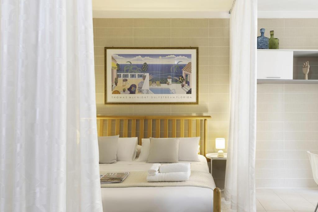 una camera da letto con un letto con cuscini bianchi di Ice Apartment - Free Wifi a Quartu SantʼElena