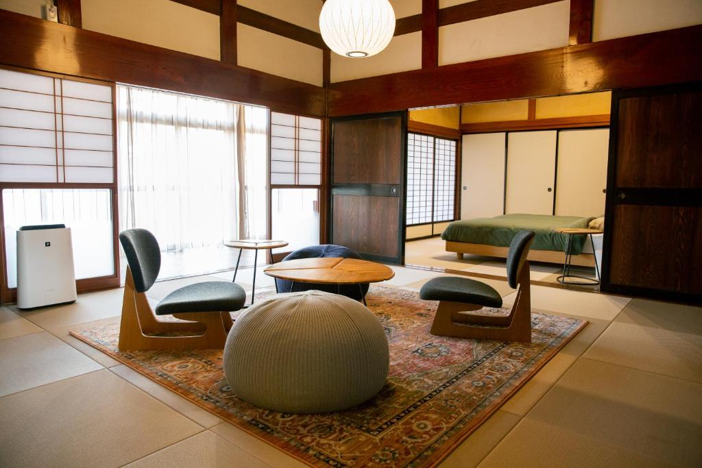 a room with chairs and a table and a bed at 町宿ORANCHI 