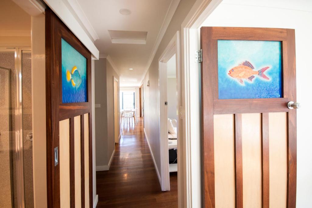 einen Flur mit einer Tür mit einem Fischgemälde darauf in der Unterkunft Clearwater Motel Apartments in Esperance