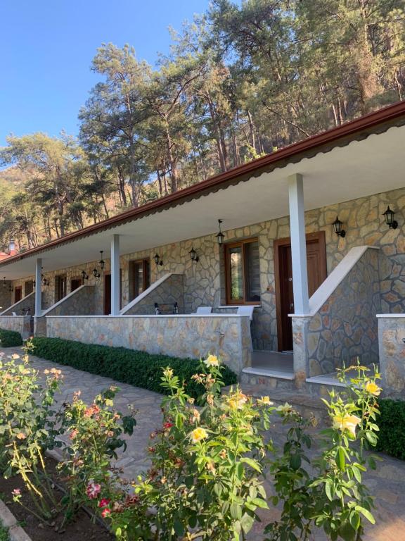 a stone house with a porch and stairs at Doga Ciftlik Konaklama in Marmaris