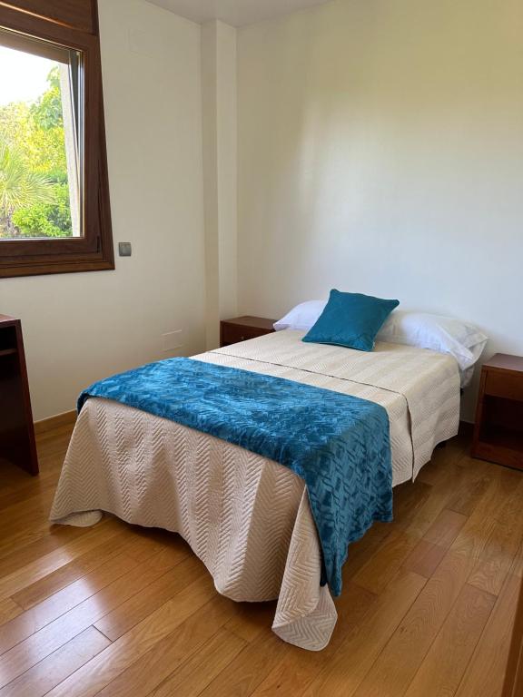 Un dormitorio con una cama con una manta azul. en A de Bego, en Mougás