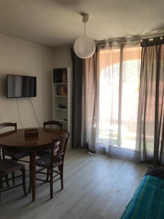 Habitación con mesa, sillas y ventana en Appartement lumineux et rénové, en Digne-les-Bains