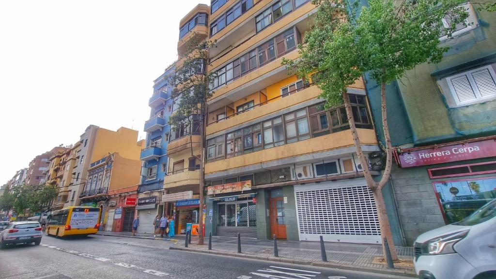 eine belebte Stadtstraße mit Gebäuden und einem Bus in der Unterkunft Playa de Las Canteras & Puerto Loft in Las Palmas de Gran Canaria