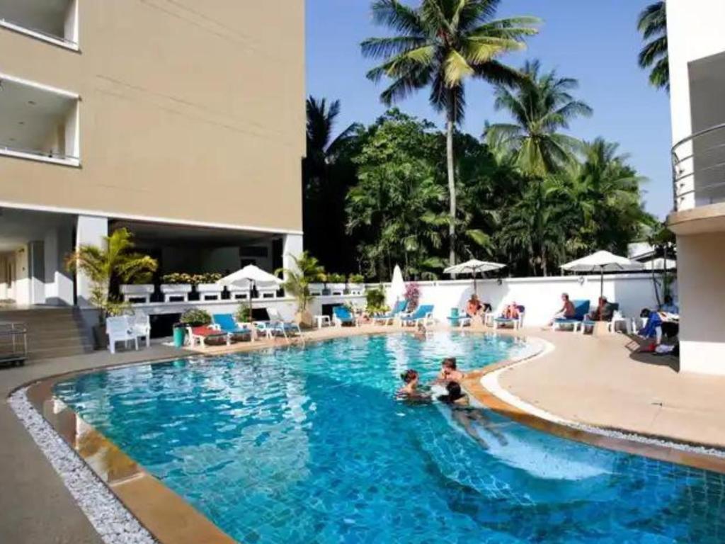 a swimming pool at a resort with people in it at GP House Phuket Patong Beach in Patong Beach