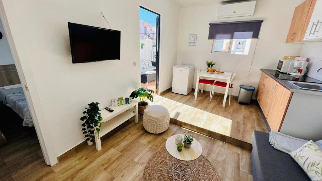 ein Wohnzimmer mit Couch und Tisch und eine Küche in der Unterkunft Apartamento Jimena Málaga en el centro de Nerja in Nerja