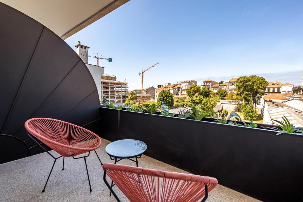 - un balcon avec vue doté de 2 chaises et d'une table dans l'établissement Nomads Lux - 1BDR Almada Cool, à Porto