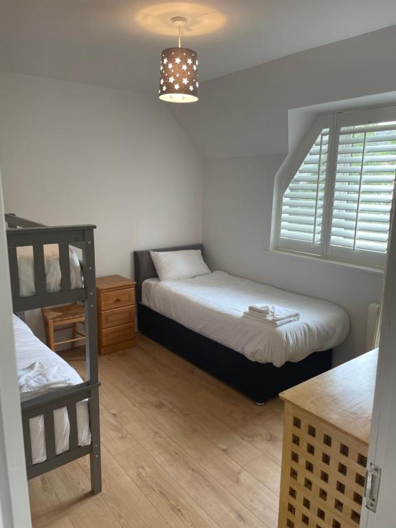 a bedroom with two beds and a bunk bed at Garinish Court Maisonette in Glengarriff