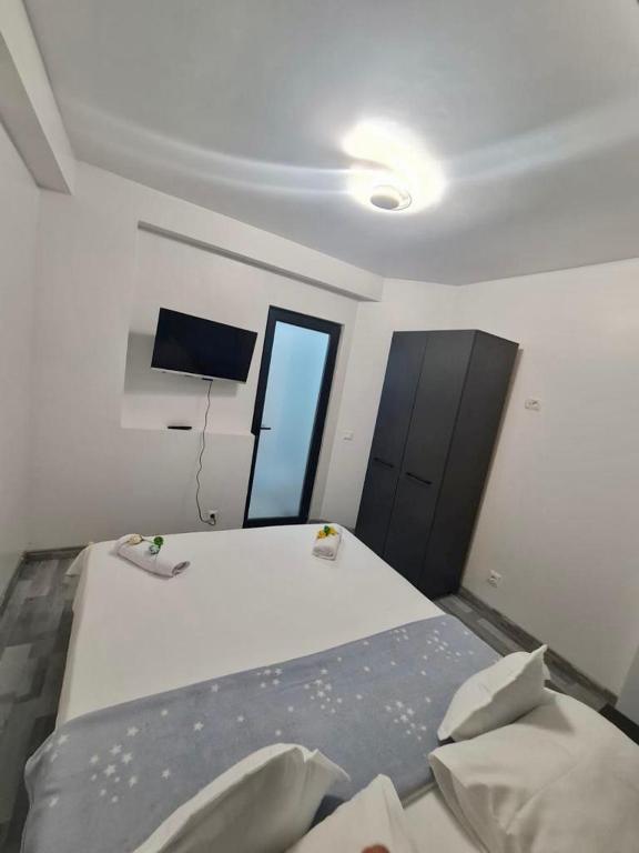 a bedroom with a bed and a television in it at Apartament Elysa in Eforie Sud