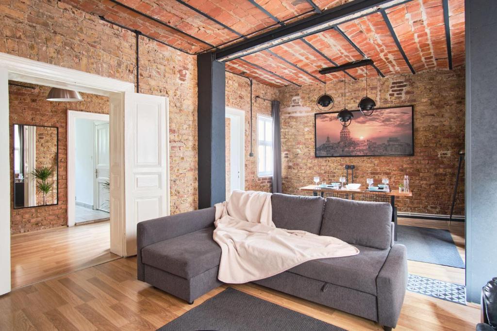 a living room with a couch and a brick wall at Taksim square, galata tower historical flat in Istanbul