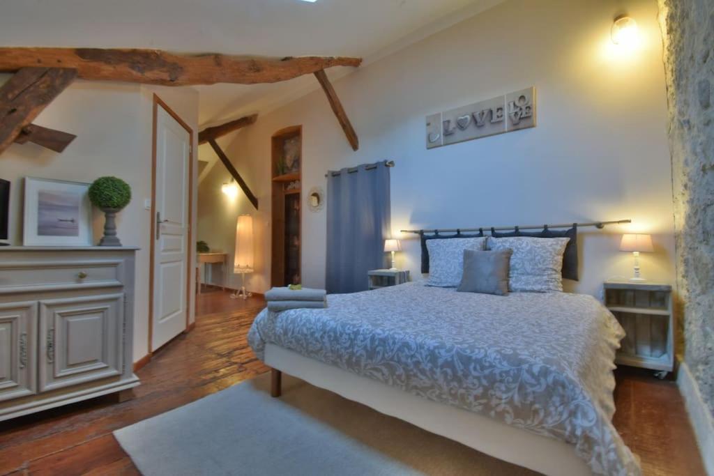 ein Schlafzimmer mit einem großen Bett in einem Zimmer mit Holzböden in der Unterkunft Chambre d'hôtes L'altitude - Domaine la Rose des vents in Castelnau-sur-lʼAuvignon