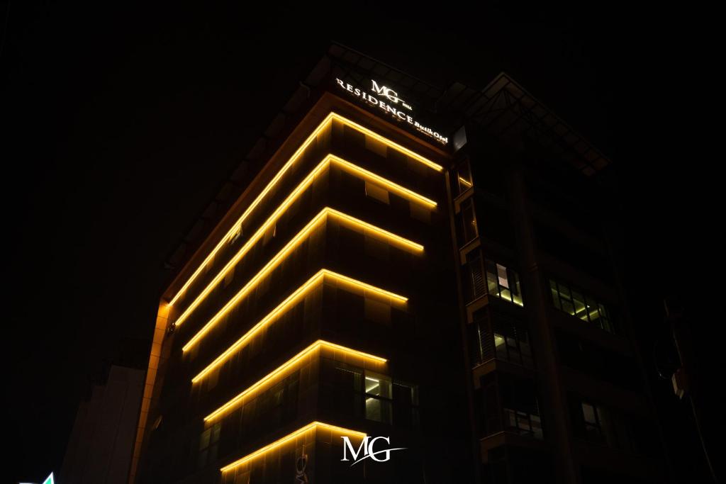 un edificio alto con luces amarillas por la noche en MG HİLL RESİDENCE BUTİK OTEL en Yeşilyurt