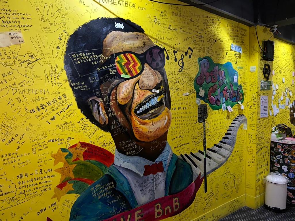 a mural of a man painted on a yellow wall at Hive Bed and Backpacker蜂巢膠囊旅店 in Hualien City