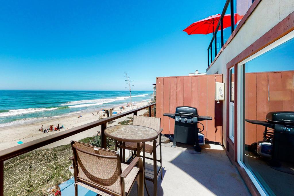 a balcony with a table and chairs and the beach at 3009 Ocean Street- Unit C & D in Carlsbad