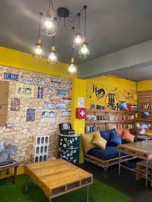 a living room with a couch and tables and shelves at Hive Bed and Backpacker蜂巢膠囊旅店 in Hualien City