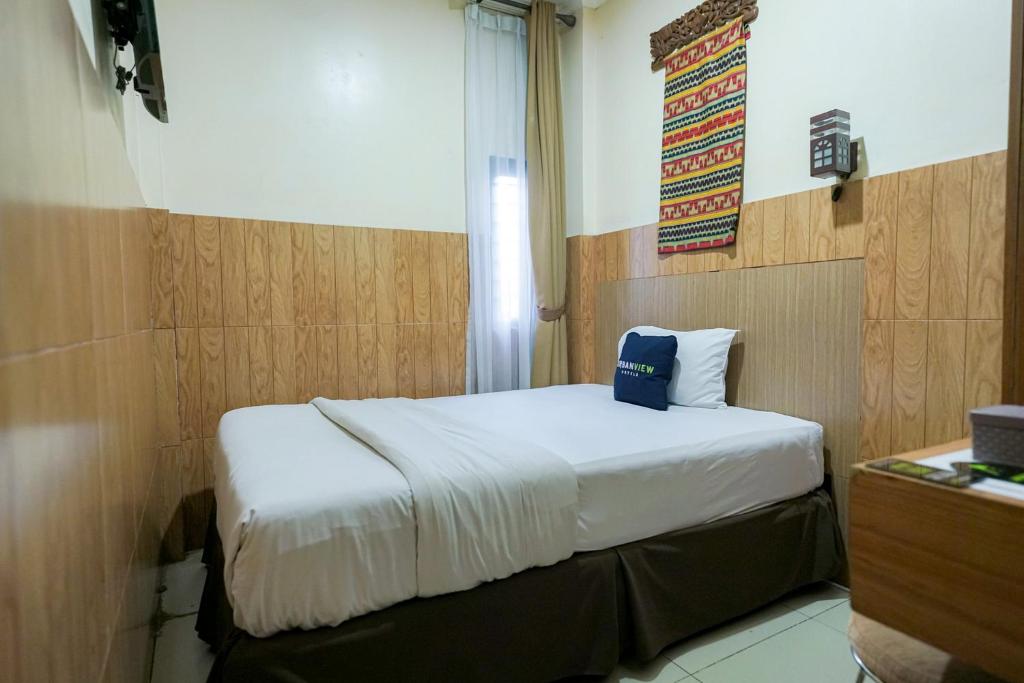 ein Schlafzimmer mit einem Bett mit einem Schild an der Wand in der Unterkunft Urbanview Hotel 58 Bintaro by RedDoorz in Pondoklang