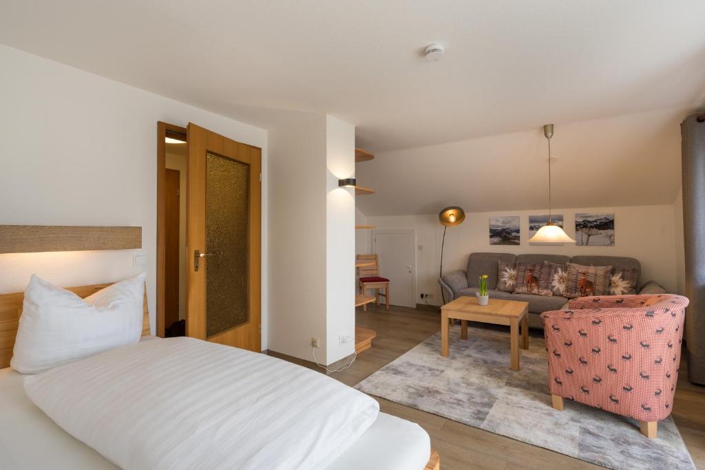 een slaapkamer met een bed en een woonkamer bij Ferienwohnung Laux in Oberstdorf
