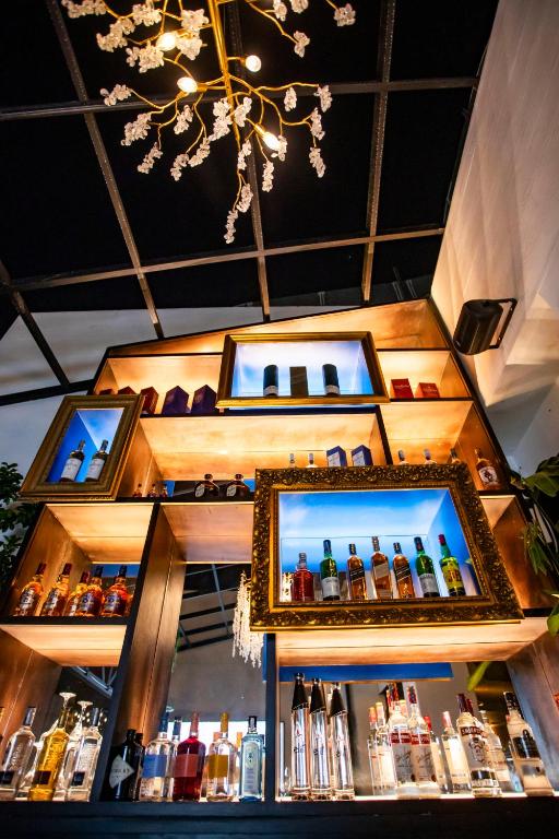 a bar with two mirrors and bottles of alcohol at Hotel Philosophy in Amman