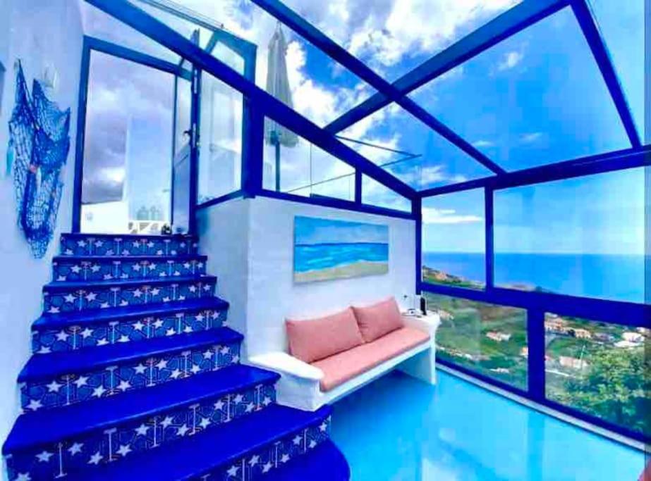 Una sala de estar con un sofá y una ventana grande. en Casa Santorini, en Ribeira Brava