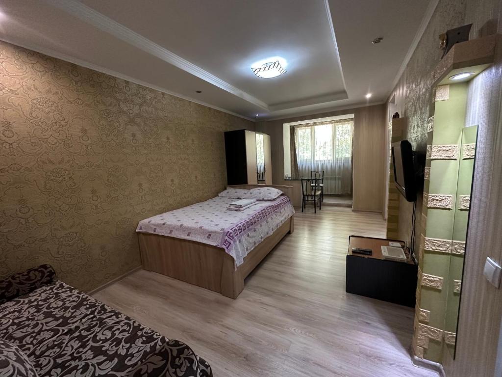 a hotel room with a bed and a dining room at Однокомнатная квартира напротив Аэропорта Алматы in Turksib
