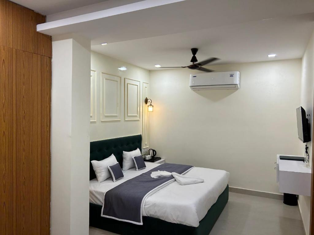 um quarto com uma cama e uma ventoinha de tecto em Hotel Cosmopolitan Rooms & Banquet em Allahabad