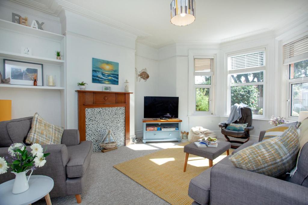 a living room with a couch and a tv at Pebbles In Budleigh in Budleigh Salterton